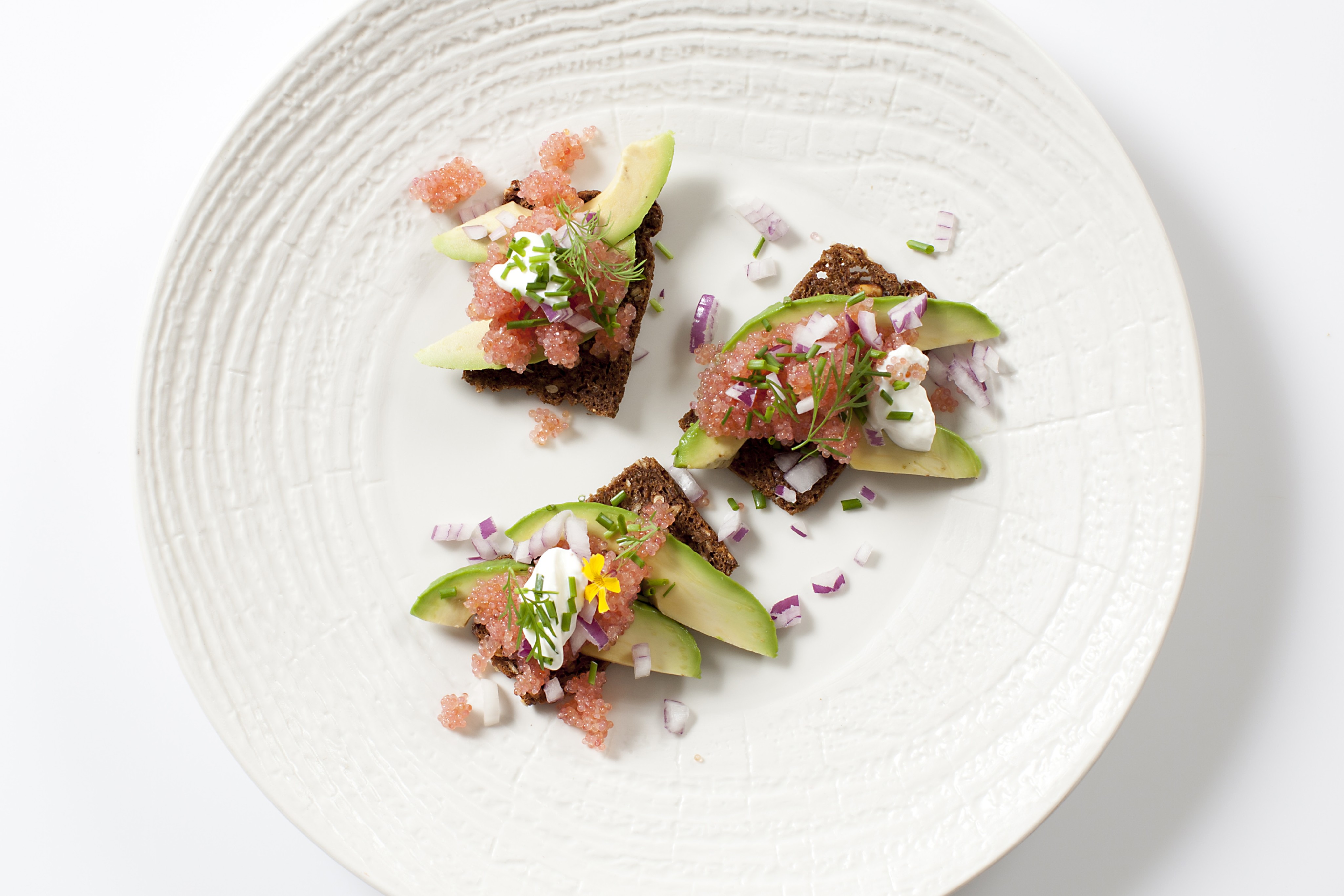 Stenbiderrogn på sprød rug chips med avokado og rødløg